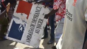 Protesters tore down the sign displaying "Embassy of France in Niger" in Niamey on July 30, 2023. © AFP