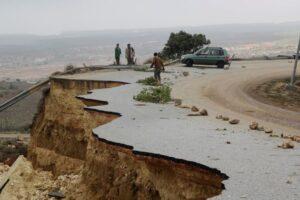 People stand in a damaged road as a powerful storm and heavy rainfall flooded hit Shahhat city, Libya, September 11, 2023. [Omar Jarhman/Reuters]