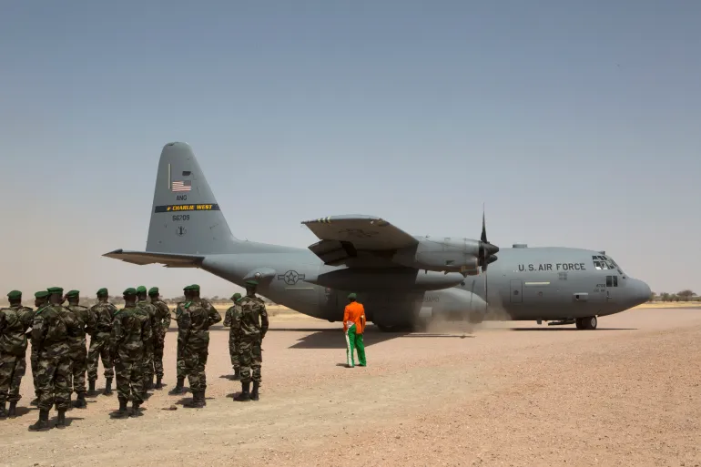 A C-130 US Air Force plane lands as Nigerien soldiers stand in formation during military exercise with US Special Forces in Diffa region in 2014 [File: Joe Penney/Reuters]