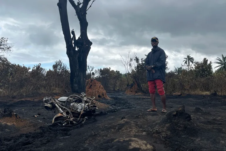 A man stands at the site of the illegal refinery explosion in Emohua, Niger Delta, Nigeria [AP Photo]
