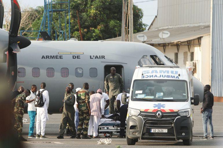 Surviving migrants, from a boat lost at sea in July and found in Cape Verde with several survivors, arrive on the runway at the Dakar-Ouakam Air Base, in Dakar, Senegal on August 21, 2023 [Ngouda Dione/Reuters]